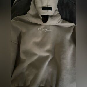 Fear of God Essentials hoodie in oatmeal beige color.